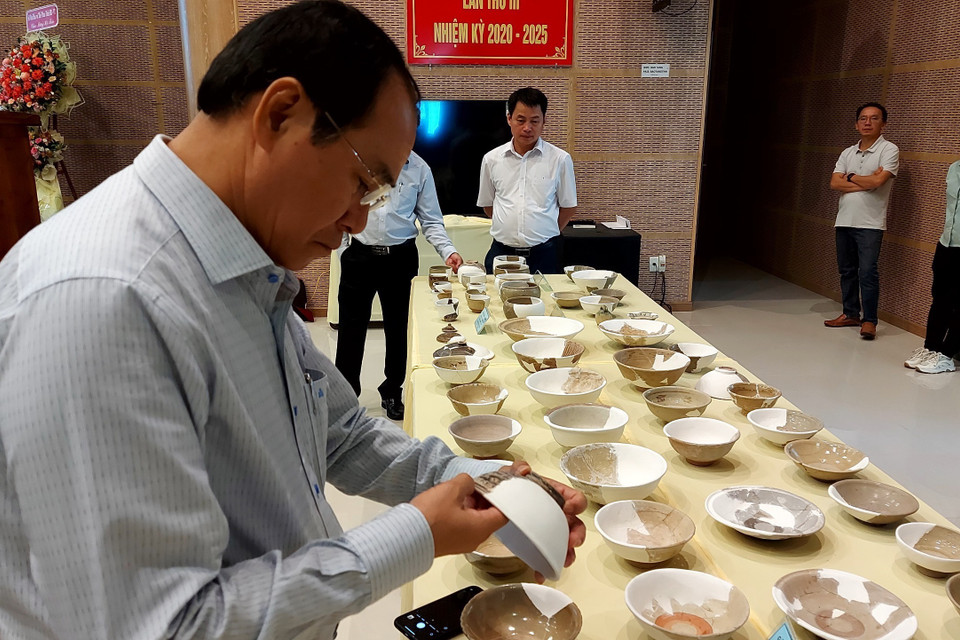 Các đại biểu tham quan nhóm đồ sứ, đồ bán sứ và đồ sành được khai quật tại di tích Vòng Thành Đá Trắng. (Ảnh: Huỳnh Sơn/TTXVN)