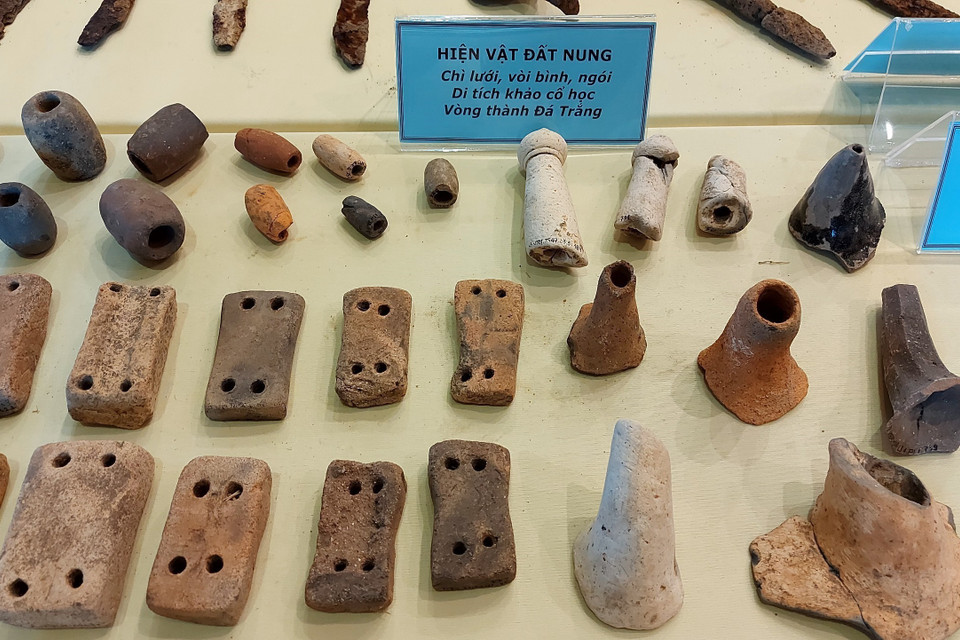 Trưng bày chì lưới, vật nhỏ làm bằng đất nung, buộc vào chài lưới đánh cá hoặc dây câu, được tìm thấy ở khu vực trung tâm của Di tích Vòng Thành Đá Trắng, với số lượng khá lớn, tổng số lên đến hơn 120 hiện vật. (Ảnh: Huỳnh Sơn/TTXVN)