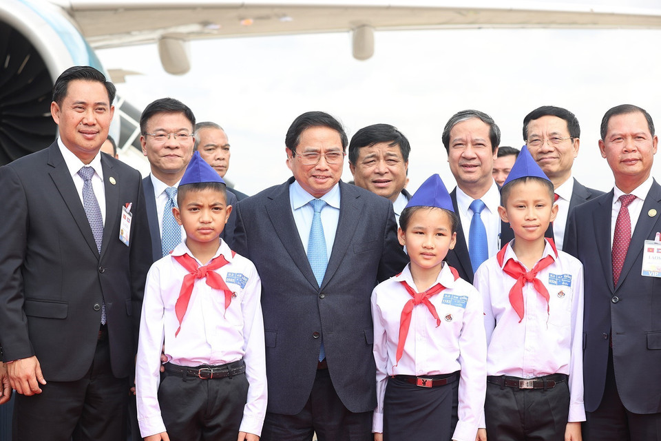  Thủ tướng Phạm Minh Chính chụp ảnh với các cháu thiếu nhi tại lễ tiễn tại sân bay Quốc tế Wattay, thủ đô Vientiane. (Ảnh: Dương Giang/TTXVN)