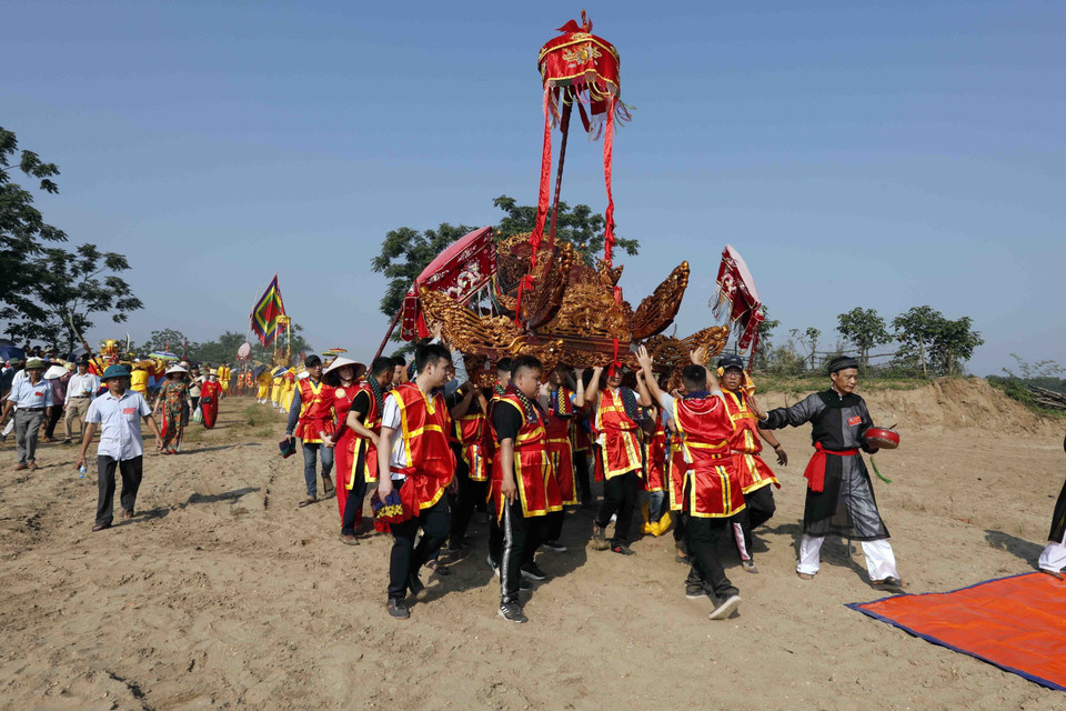 Những cỗ kiệu được rước ra bãi cát, nơi tương truyền Chử Đồng Tử và Tiên Dung Công chúa gặp nhau. (Ảnh: Trấn Việt/TTXVN)