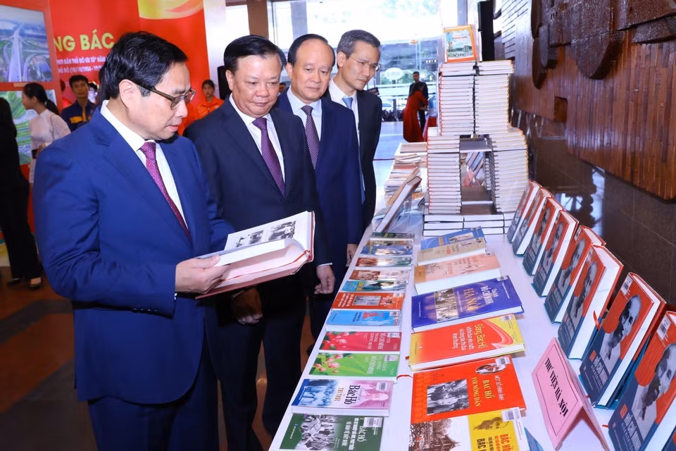 Thủ tướng Phạm Minh Chính cùng các đại biểu tham quan trưng bày sách Những bông hoa đẹp. (Ảnh: Dương Giang/TTXVN)