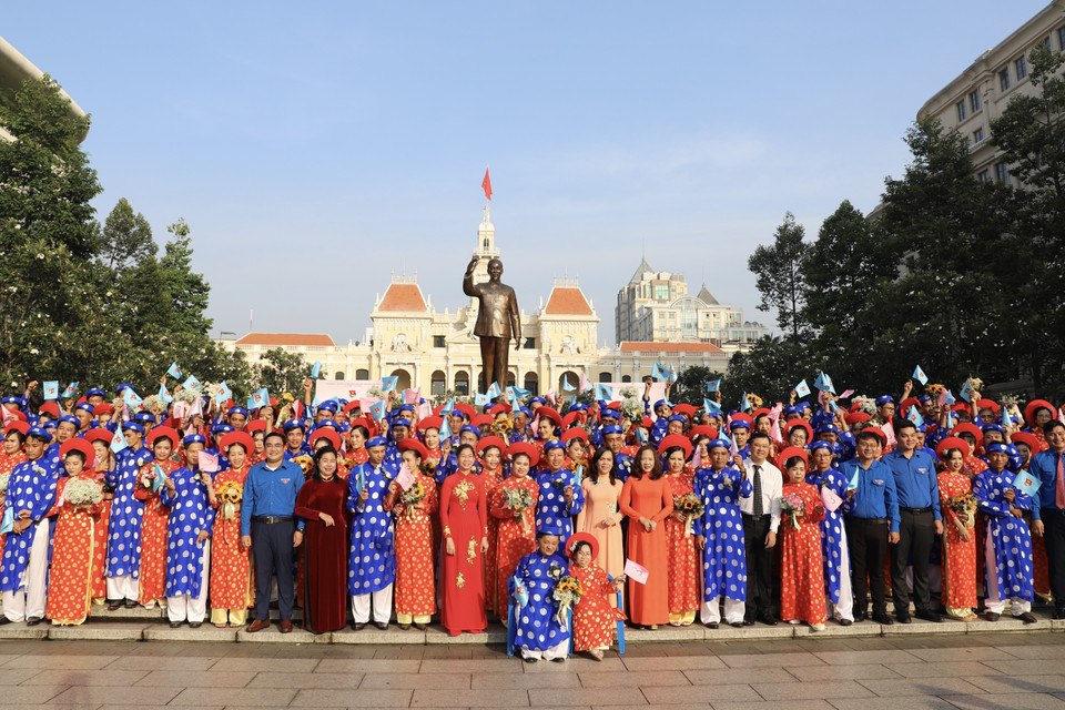 Các cặp đôi chụp hình lưu niệm với lãnh đạo Thành phố Hồ Chí Minh và Ban tổ chức sau lễ dâng hoa. (Ảnh: Hồng Giang/TTXVN)