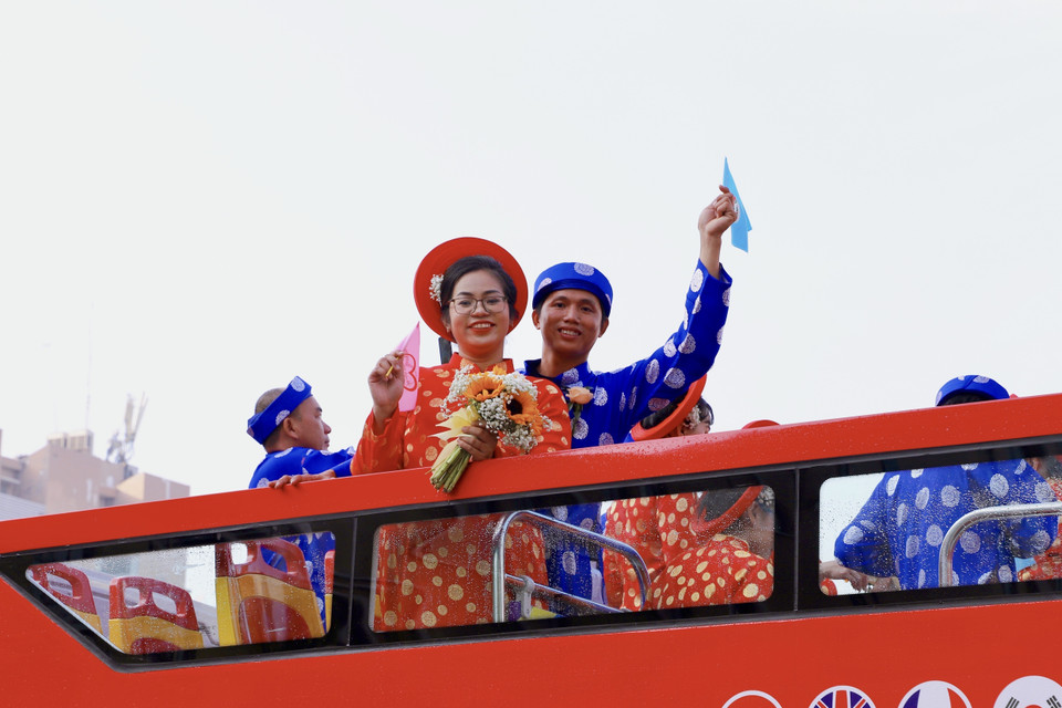 Xe buýt hai tầng đưa các cặp cô dâu, chú rể diễu hành qua những tuyến đường lớn ở Thành phố Hồ Chí Minh. (Ảnh: Hồng Giang/TTXVN)