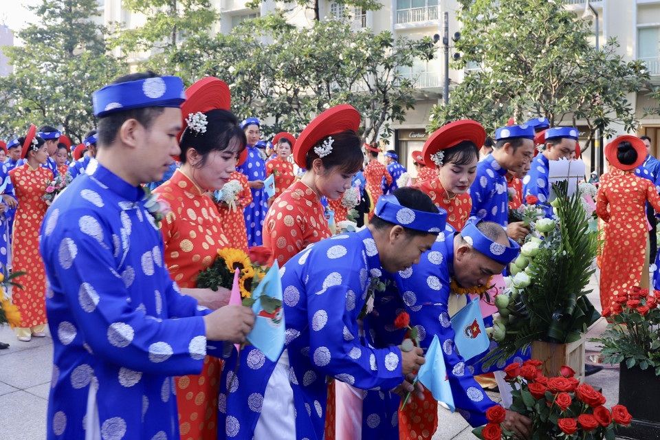 Các cặp vợ chồng thanh niên công nhân dâng hoa tại Tượng đài Chủ tịch Hồ Chí Minh. (Ảnh: Hồng Giang/TTXVN)
