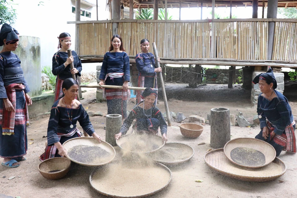 Phụ nữ trong làng tập trung giã, sàng sẩy để lựa chọn hạt Cào đạt chuẩn nấu rượu cần. (Ảnh: Hồng Điệp/TTXVN)