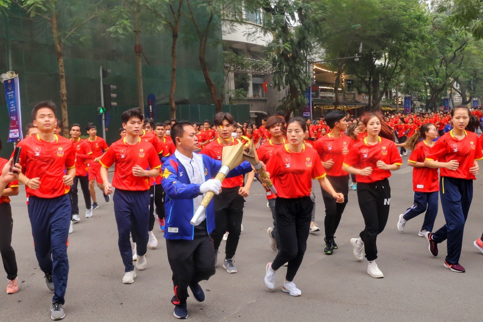 Tiếp lửa cho đoàn rước đuốc trên đường phố Hà Nội. (Ảnh: Tuấn Đức/TTXVN)