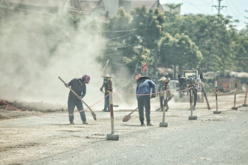 Công nhân dọn dẹp chuẩn bị thảm nhựa. (Ảnh: Danh Lam/TTXVN)