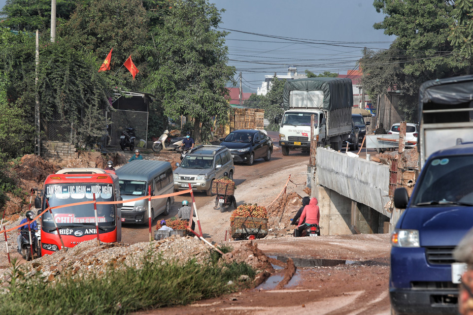 Người dân vất vả chở vải đi bán trong điều kiện quốc lộ 31 đang thi công. (Ảnh: Danh Lam/TTXVN)