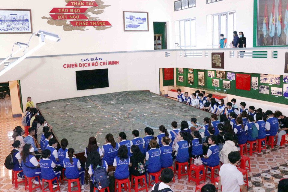 Sinh viên trường Đại học Kinh tế Thành phố Hồ Chí Minh tìm hiểu diễn biến chiến dịch Hồ Chí Minh qua mô hình sa bàn chiến dịch rộng60 m2 đặt ngay trung tâm Bảo tàng Chiến dịch Hồ Chí Minh. (Ảnh: Xuân Khu/TTXVN)