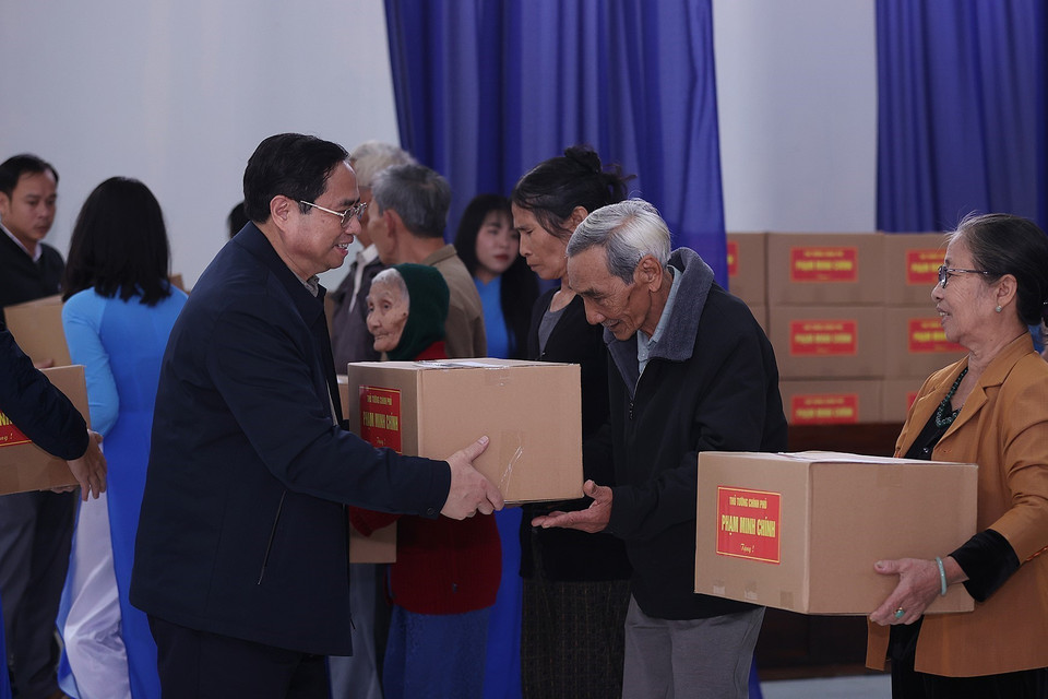 Thủ tướng Phạm Minh Chính tặng quà các hộ dân thuộc diện giải phóng mặt bằng của dự án tuyến đường cao tốc Bắc-Nam phía Đông. (Ảnh: Dương Giang/TTXVN)