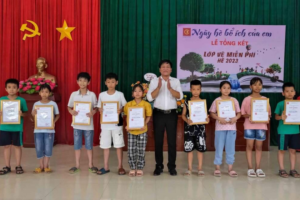 Họa sỹ Hoàng Tuấn Việt, Chủ nhiệm Câu lạc bộ Mỹ thuật Cổ Đô trao giấy khen cho những học sinh hoàn thành xuất sắc khóa học. (Nguồn: Vietnam+)