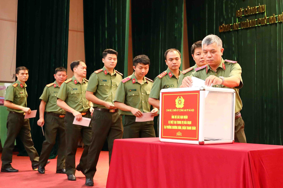 Cán bộ, chiến sỹ Công an thành phố Hà Nội ủng hộ các nạn nhân đã tử vong trong vụ cháy chung cư mini tại phố Khương Hạ (Thanh Xuân, Hà Nội). (Ảnh: Phạm Kiên/TTXVN)