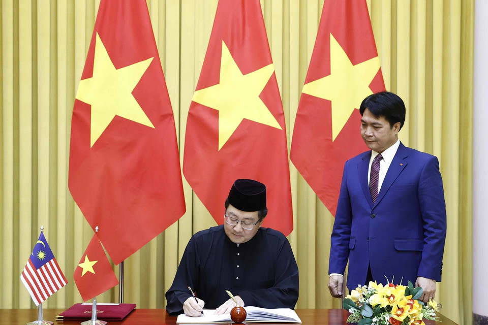 Đại sứ Malaysia Tan Yang Thai viết lưu bút tại Phủ Chủ tịch. (Ảnh: Thống Nhất/TTXVN)