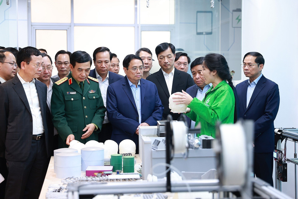 Thủ tướng Phạm Minh Chính nghe giới thiệu về các đơn vị nghiên cứu, sản xuất trong Trung tâm Đổi mới sáng tạo Quốc gia (NIC). (Ảnh: Dương Giang/TTXVN)