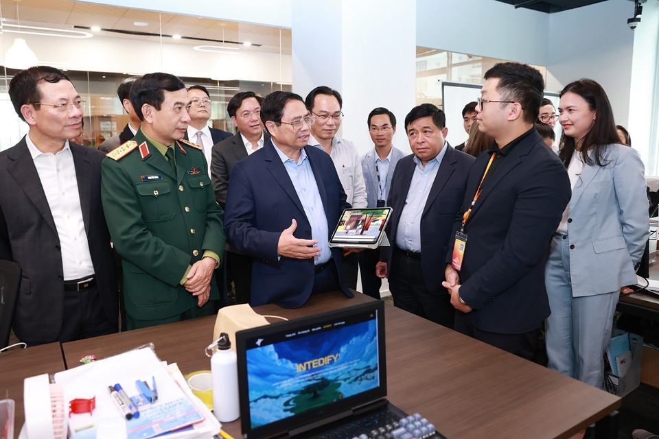 Thủ tướng Phạm Minh Chính trò chuyện với các cán bộ, nhân viên trong các đơn vị nghiên cứu, sản xuất của Trung tâm Đổi mới sáng tạo Quốc gia (NIC). (Ảnh: Dương Giang/TTXVN)