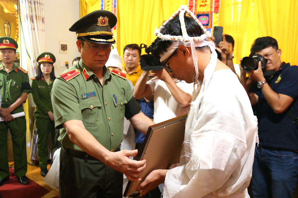 Thiếu tướng Lê Vinh Quy, Giám đốc Công an tỉnh Đắk Lắk trao Bằng Tổ quốc ghi công cho gia đình Thiếu tá Hoàng Trung, cán bộ Công an xã Ea Ktur, huyện Cư Kuin. (Ảnh: Quang Thái/TTXVN)