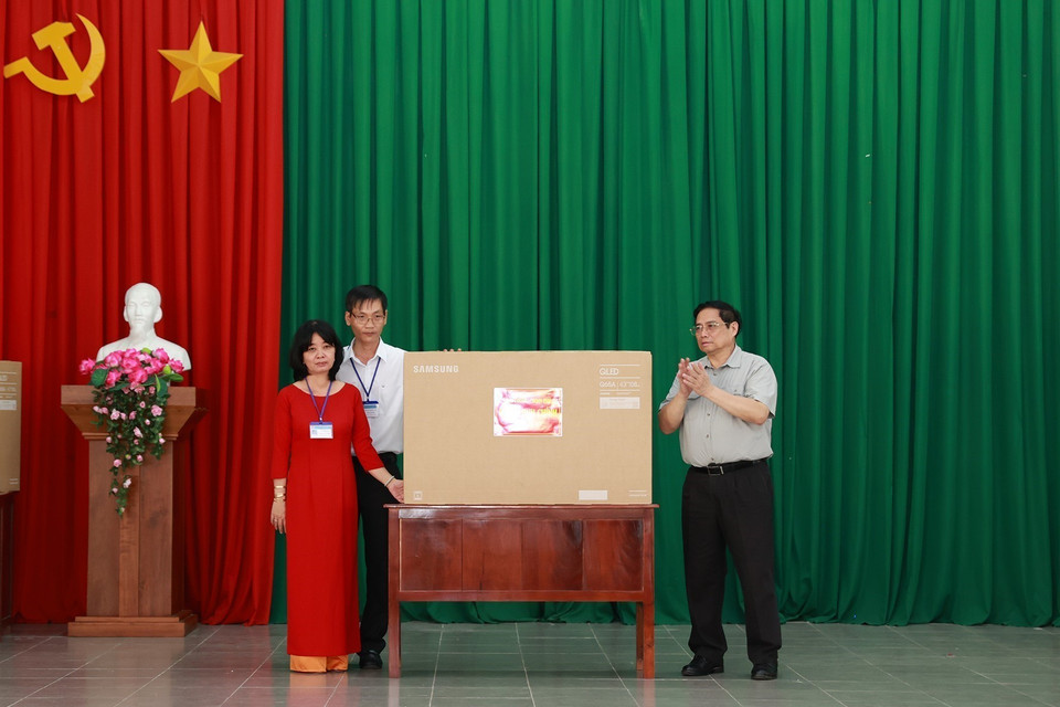 Thủ tướng Phạm Minh Chính tặng quà cho giáo viên Trường nuôi dạy trẻ em khuyết tật Bến Tre. (Ảnh: Dương Giang/TTXVN)