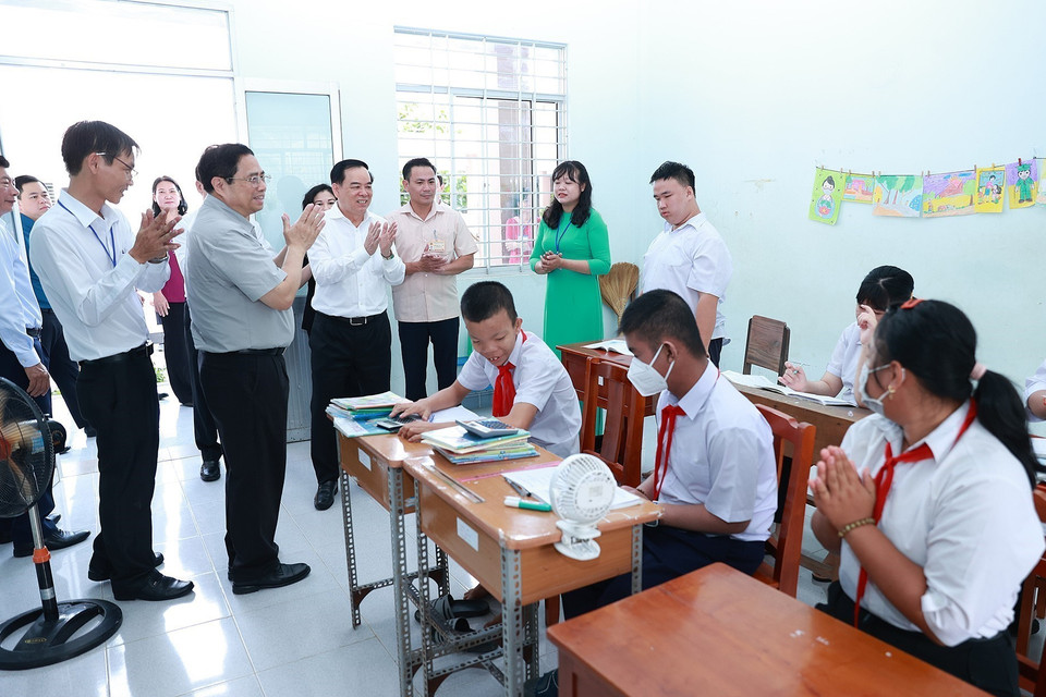 Thủ tướng Phạm Minh Chính thăm, động viên học sinh Trường nuôi dạy trẻ em khuyết tật Bến Tre. (Ảnh: Dương Giang/TTXVN)