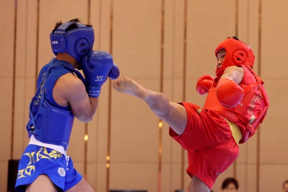 Vận động viên Bùi Trường Giang (giáp đỏ) tiếp tục mang về cho đội tuyển Wushu tấm huy chương Vàng thứ 2 ở nội dung Tán thủ hạng 60kg nam sau khi đánh bại vận động viên Gideon Fred Wayan Padua (Philippines, giáp xanh) trong trận chung kết. (Ảnh: Hoàng Linh/TTXVN)