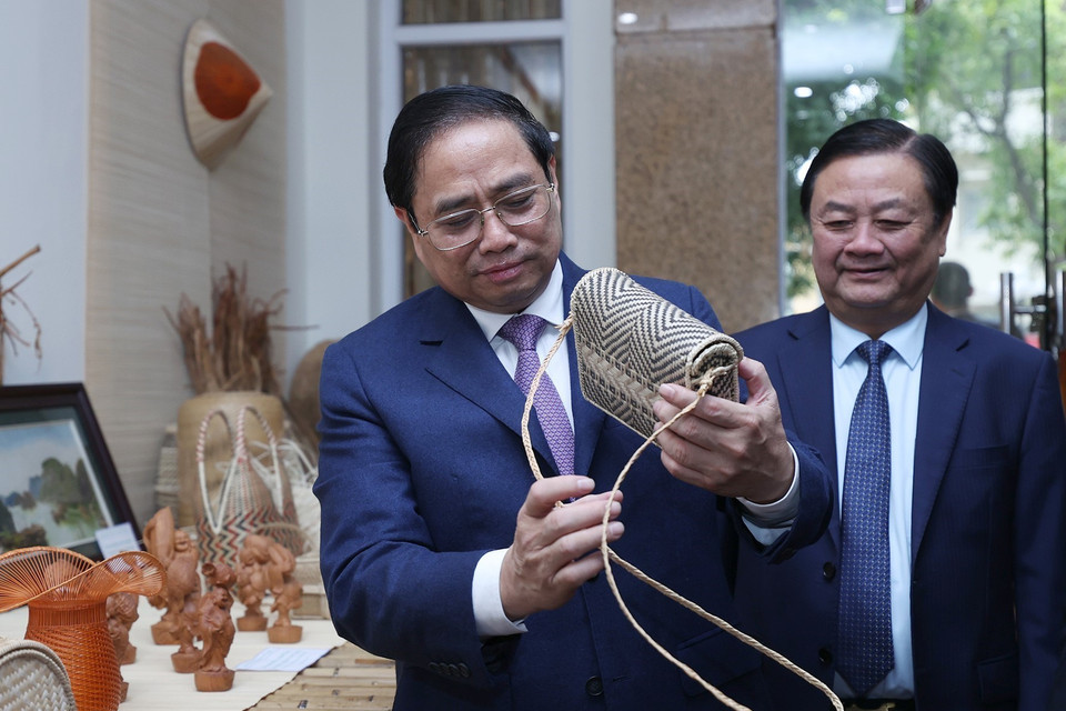 Hình ảnh Thủ tướng Phạm Minh Chính xem trưng bày sản phẩm nông nghiệp, thủ công mỹ nghệ. (Ảnh: Dương Giang/TTXVN)