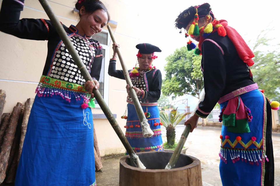 Phụ nữ dân tộc Si La giã bánh giầy. (Ảnh: Quý Trung/TTXVN)