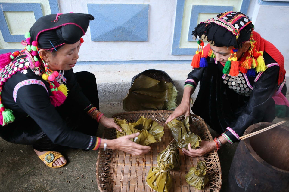 Phụ nữ dân tộc Si La chuẩn bị các lễ vật để cúng tổ tiên và thần linh. (Ảnh: Quý Trung/TTXVN)