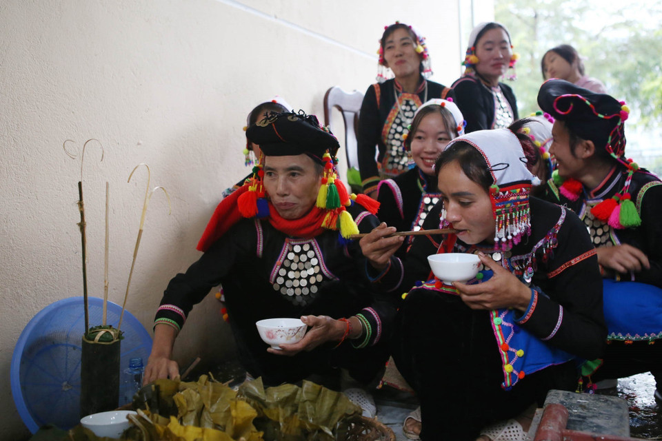 Tất cả các thành viên tại lễ cúng tổ tiên đều được thưởng thức những lễ vật đã cúng tổ tiên với thần linh để lấy may. (Ảnh: Quý Trung/TTXVN)