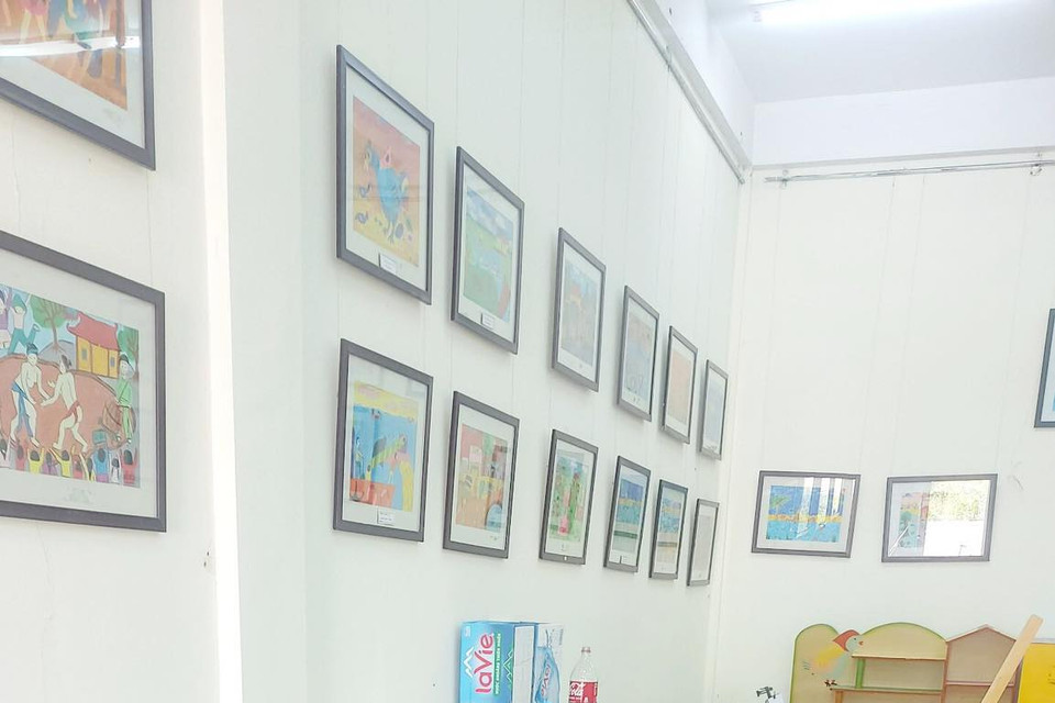 Các em thiếu nhi say sưa bên giá vẽ. (Nguồn: Vietnam+)