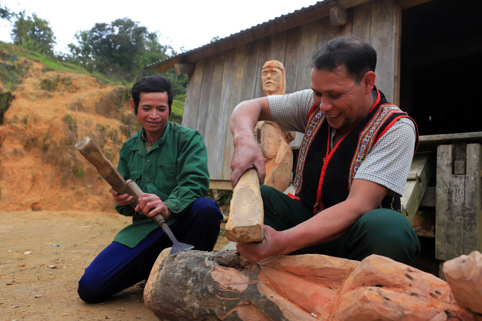 Nghệ nhân ưu tú A Gông (phải) truyền dạy kỹ năng tạc tượng gỗ của người Mơ Nâm cho thanh niên tại làng Kon Du (xã Măng Cành, huyện Kon Plông, tỉnh Kon Tum). (Ảnh: Khoa Chương/TTXVN)
