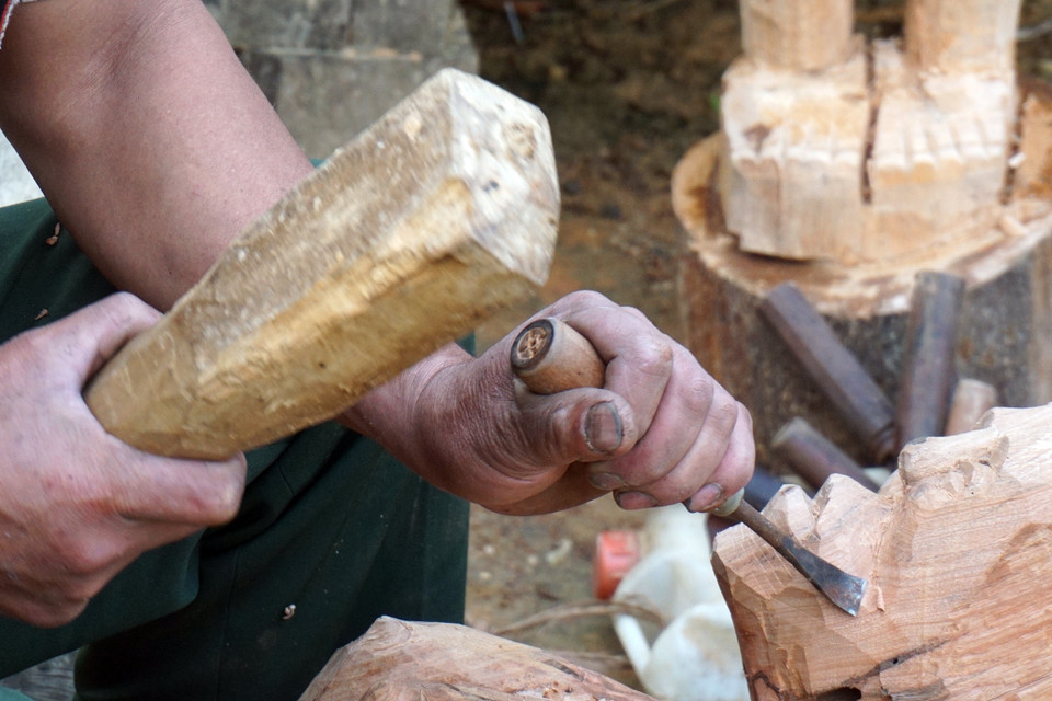 Nhờ tính cần cù, tài hoa và sự sáng tạo, cùng với con mắt tinh tường, tỷ mỉ và đôi bàn tay khéo léo, nghệ nhân A Gông đã tạo ra những sản phẩm tượng gỗ đẹp mắt, chân thực mang đậm bản sắc văn hóa của cộng đồng dân tộc Mơ Nâm. (Ảnh: Khoa Chương/TTXVN) 