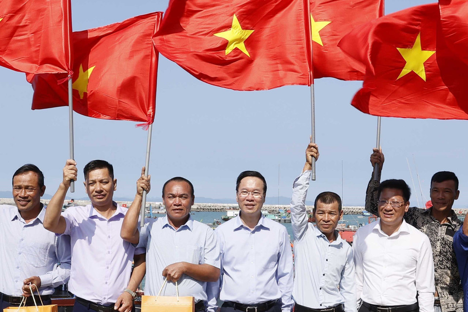 Chủ tịch nước Võ Văn Thưởng tặng cờ Tổ quốc cho ngư dân tại khu neo đậu tránh trú bão, huyện đảo Cô Tô, Quảng Ninh. (Ảnh: Thống Nhất/TTXVN)