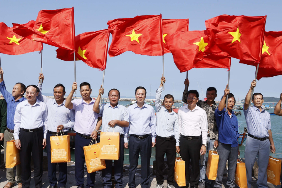 Chủ tịch nước Võ Văn Thưởng tặng cờ Tổ quốc cho ngư dân tại khu neo đậu tránh trú bão, huyện đảo Cô Tô, Quảng Ninh. 