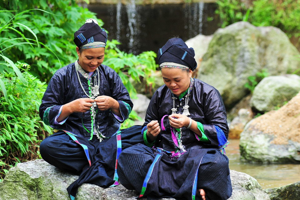 Đoàn viên thanh niên tranh thủ làm trang phục cho búp bê những lúc nông nhàn. (Ảnh: Nam Thái/TTXVN)