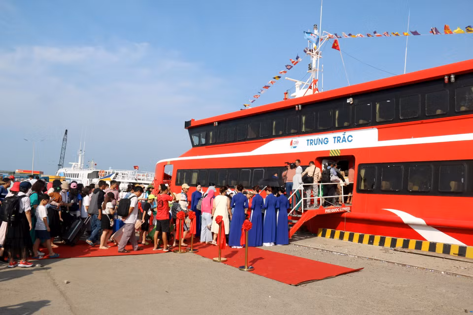 Người dân và du khách đi chuyến đầu tiên của tàu tốc hai thân lớn nhất trên tuyến vận tải biển Phan Thiết-Phú Quý. (Ảnh: Nguyễn Thanh/TTXVN)
