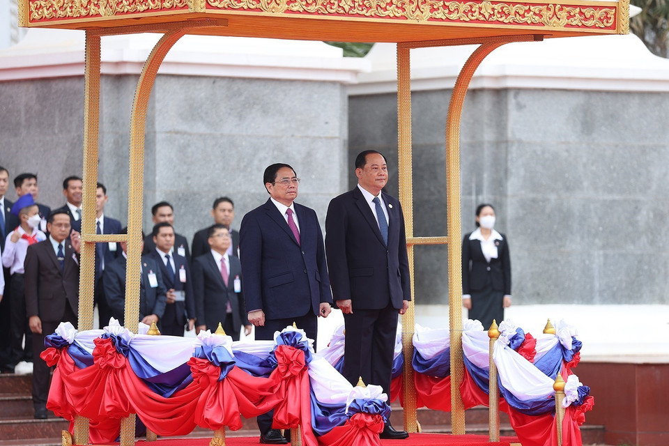 Hình ảnh Thủ tướng Phạm Minh Chính và Thủ tướng Lào Sonexay Siphandone nghe quân nhạc cử Quốc thiều hai nước. (Ảnh: Dương Giang/TTXVN)