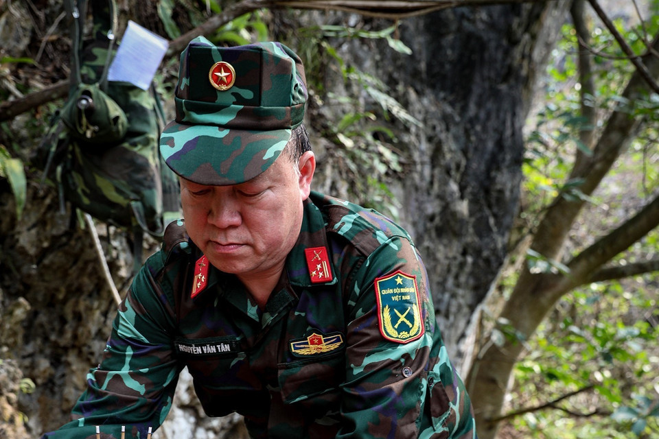 Thượng tá Nguyễn Văn Tân - Chính trị viên đội Tìm kiếm quy tập hài cốt liệt sỹ thắp nén hương tại nơi tìm được hài cốt các chiến sĩ đã hi sinh (ảnh chụp tại xã Thanh Thủy, huyện Vị Xuyên). (Ảnh: Hoàng Hiếu/TTXVN)