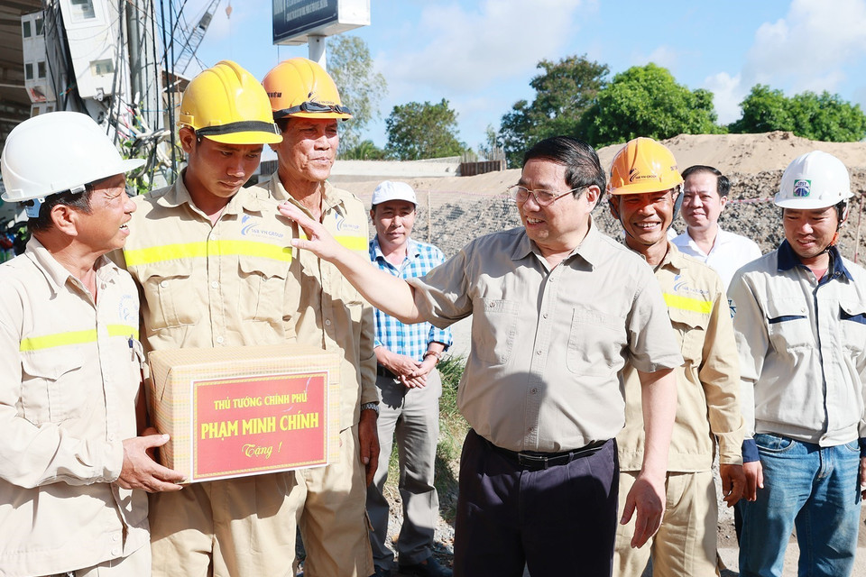 Thủ tướng Phạm Minh Chính tặng quà cho các công nhân thi công Dự án nâng cấp Quốc lộ 30 đoạn Cao Lãnh-Hồng Ngự. (Ảnh: Dương Giang/TTXVN)
