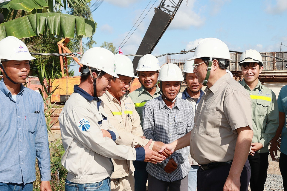 Hình ảnh Thủ tướng Phạm Minh Chính với công nhân thi công Dự án nâng cấp Quốc lộ 30 đoạn Cao Lãnh- Hồng Ngự. (Ảnh: Dương Giang/TTXVN)