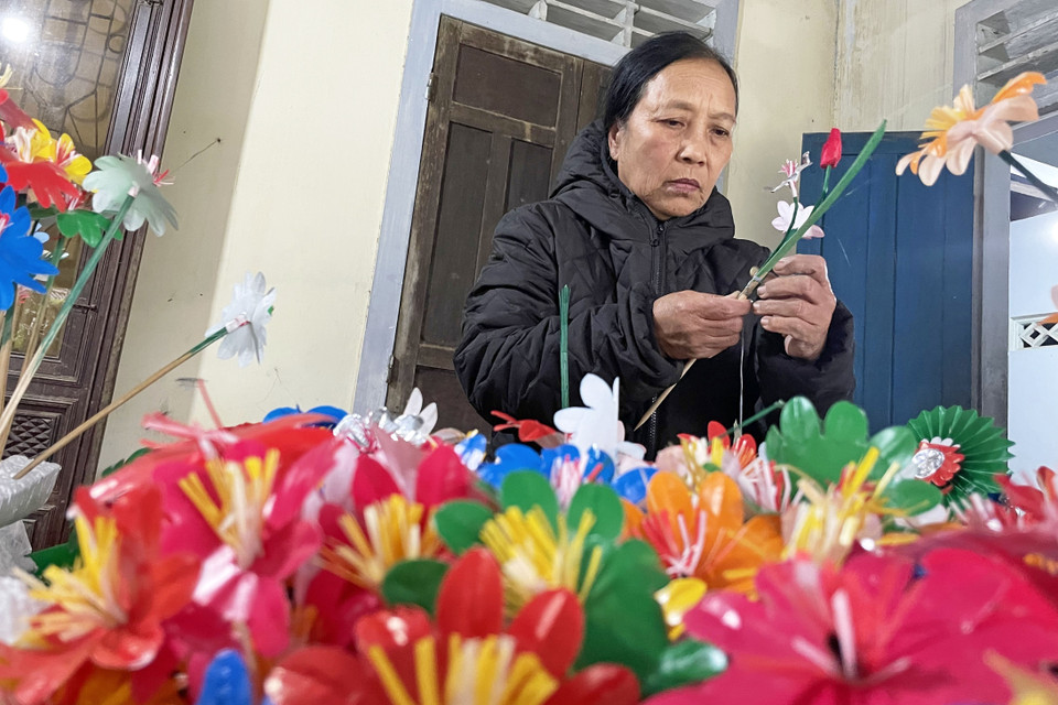 Các công đoạn để làm nên hoa giấy Thanh Tiên khá công phu và cầu kỳ. Sau khi cắt, dán tạo nên những loài hoa đẹp, nghệ nhân sẽ đính kết các loài hoa này tạo thành những cành hoa đầy màu sắc. (Ảnh: Mai Trang/TTXVN)