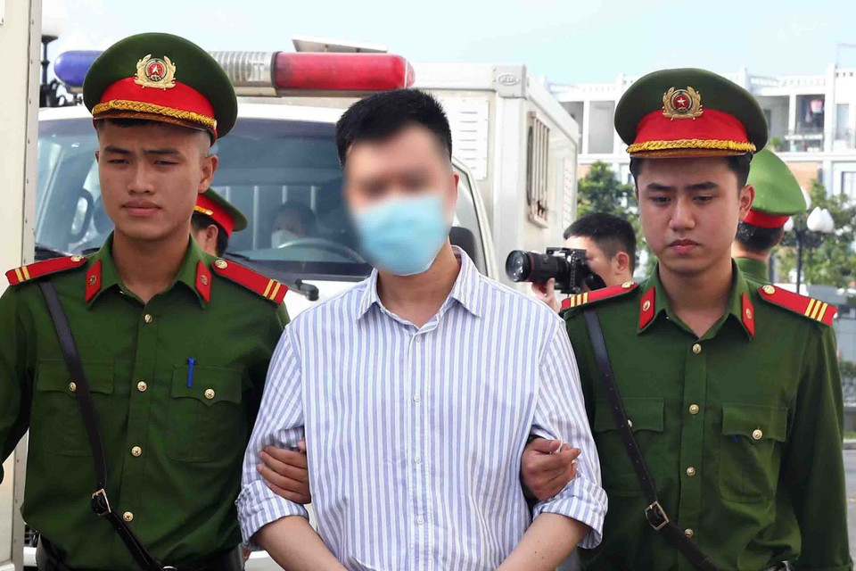 Lực lượng chức năng dẫn giải các bị cáo tới phiên tòa xét xử. (Ảnh: Phạm Kiên/TTXVN)