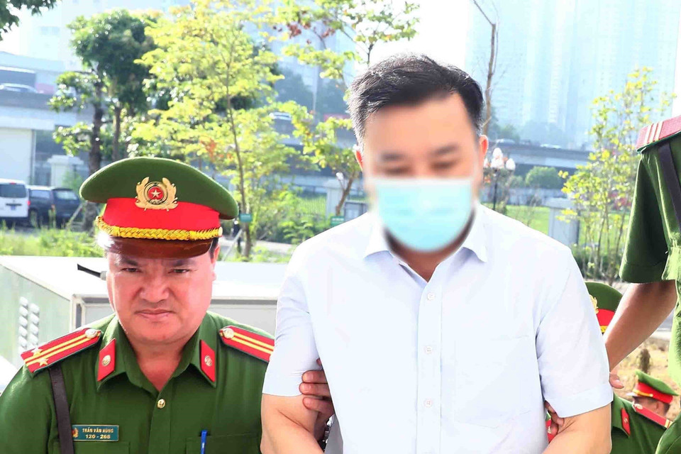 Lực lượng chức năng dẫn giải bị cáo Chử Xuân Dũng, cựu Phó Chủ tịch Ủy ban Nhân dân thành phố Hà Nội, tới phiên tòa xét xử. (Ảnh: Phạm Kiên/TTXVN)