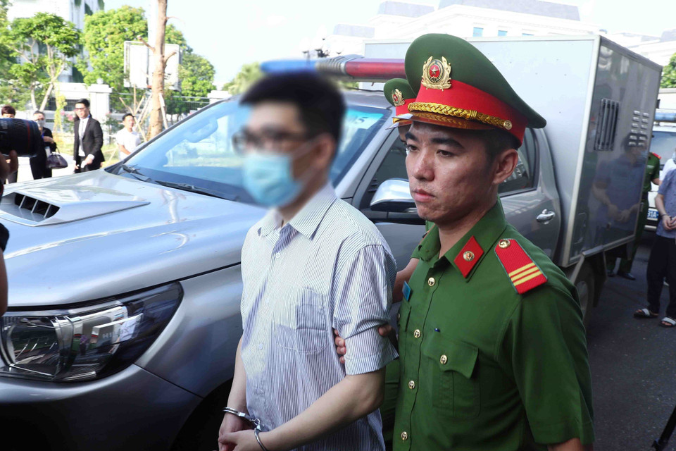 Lực lượng chức năng dẫn giải bị cáo Nguyễn Quang Linh, cựu Trợ lý Phó Thủ tướng, tới phiên tòa xét xử. (Ảnh: Phạm Kiên/TTXVN)