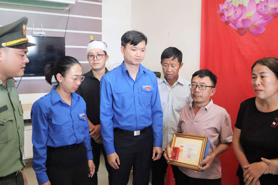 Trung ương Đoàn truy tặng Huy hiệu Tuổi trẻ Dũng cảm cho liệt sỹ, Đại úy Nguyễn Đăng Nhân đến gia đình chiến sỹ. (Ảnh: Hoài Thu/TTXVN)