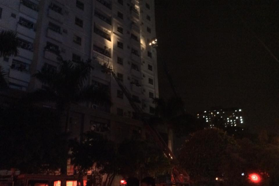 Đến thời điểm 21 giờ 45 cùng ngày, cơ quan chức năng vẫn nỗ lực yêu cầu những người mắc kẹt sử dụng khăn bịt mũi chống khói và di chuyển ra phía các cửa sổ để lực lượng cứu hộ giải cứu. (Ảnh: Sơn Bách/Vietnam+)