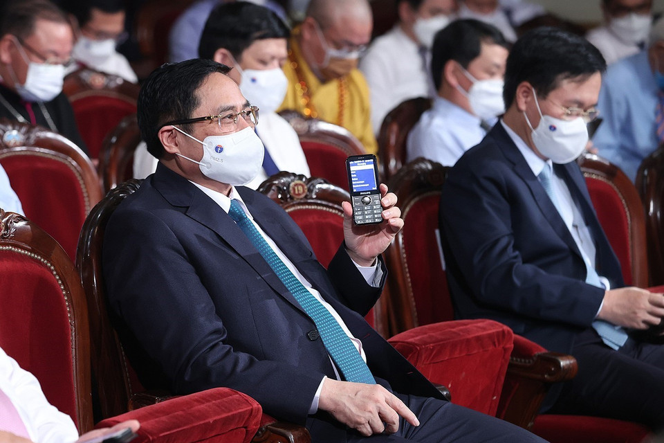 Thủ tướng Phạm Minh Chính và các đại biểu nhắn tin ủng hộ Quỹ vaccine. (Ảnh: Dương Giang/TTXVN)