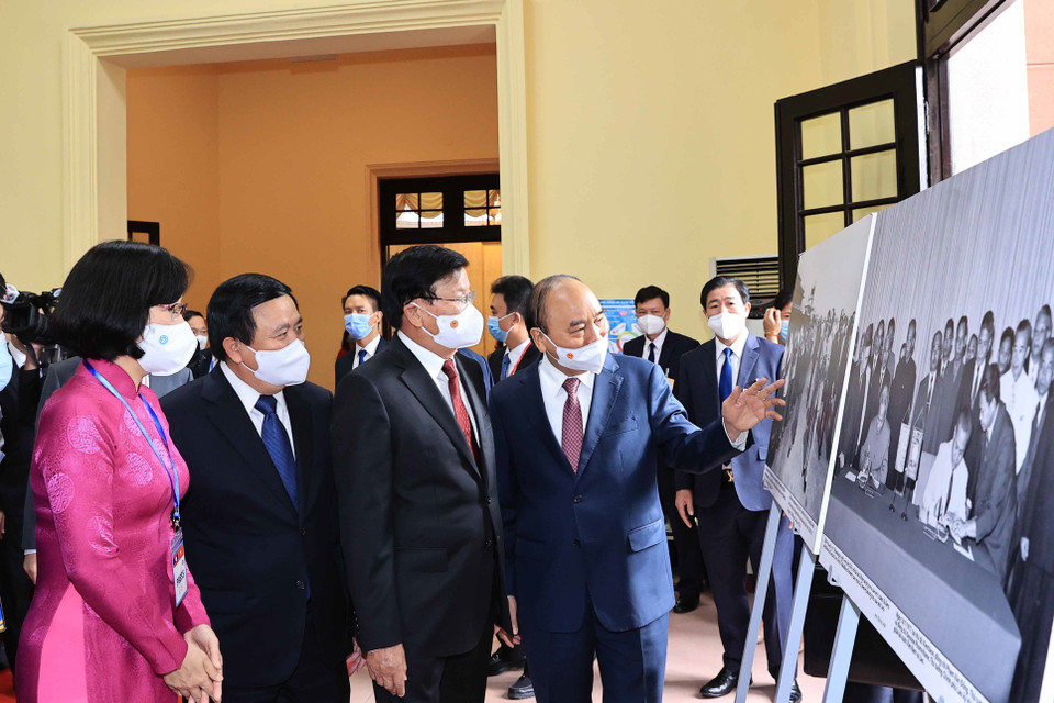 Phó Tổng Giám đốc Thông tấn xã Việt Nam Vũ Việt Trang giới thiệu trưng bày ảnh của TTXVN với Tổng Bí thư, Chủ tịch nước Lào Thongloun Sisoulith và Chủ tịch nước Nguyễn Xuân Phúc. (Ảnh: Thống Nhất/TTXVN)