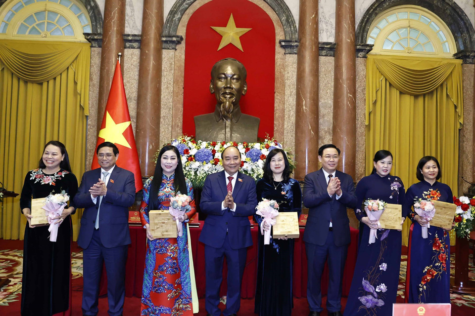Chủ tịch nước Nguyễn Xuân Phúc, Thủ tướng Chính phủ Phạm Minh Chính, Chủ tịch Quốc hội Vương Đình Huệ tặng hoa cho các nữ đại biểu. (Ảnh: Thống Nhất/TTXVN)