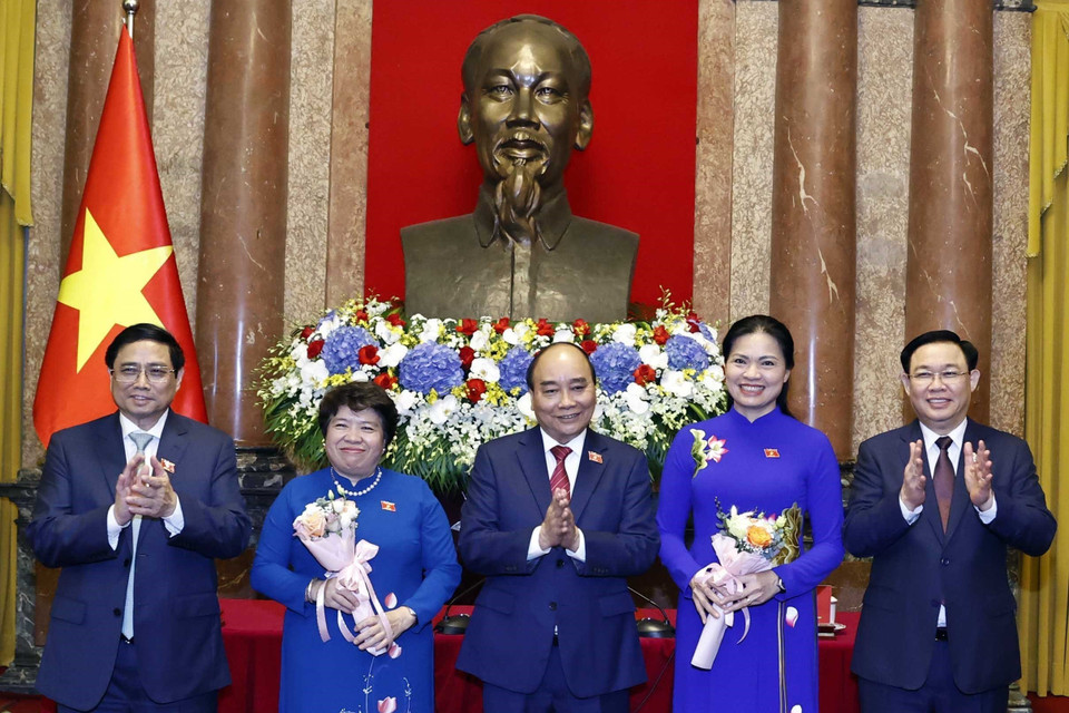 Chủ tịch nước Nguyễn Xuân Phúc, Thủ tướng Chính phủ Phạm Minh Chính, Chủ tịch Quốc hội Vương Đình Huệ tặng hoa cho đại biểu Hà Thị Nga, Chủ tịch Hội Liên hiệp Phụ nữ Việt Nam và đại biểu Nguyễn Thuý Anh, Chủ tịch Nhóm nữ đại biểu Quốc hội khoá XV. (Ảnh: Thống Nhất/TTXVN)