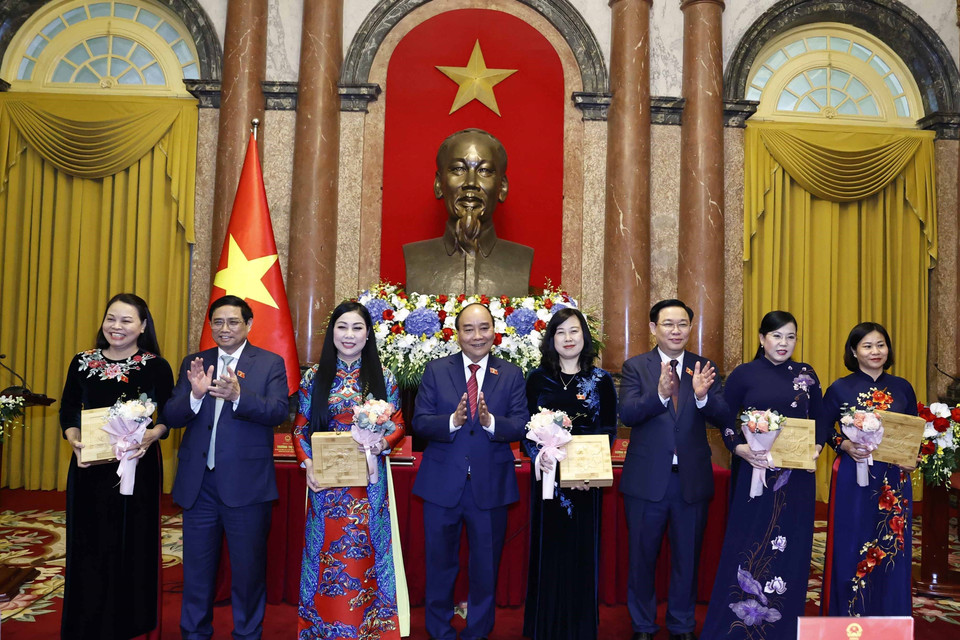 Chủ tịch nước Nguyễn Xuân Phúc, Thủ tướng Chính phủ Phạm Minh Chính, Chủ tịch Quốc hội Vương Đình Huệ tặng hoa cho các nữ đại biểu, chiều 20/10/2022. (Ảnh: Thống Nhất/TTXVN)