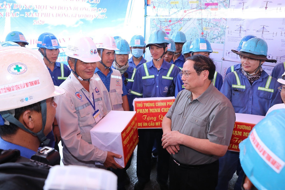 Thủ tướng Phạm Minh Chính tặng quà động viên công nhân xây dựng cầu Mỹ Thuận 2. (Ảnh: Dương Giang/TTXVN)